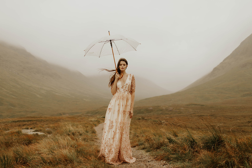 bride standing near the misty Glencoe mountains of the Scottish Highlands