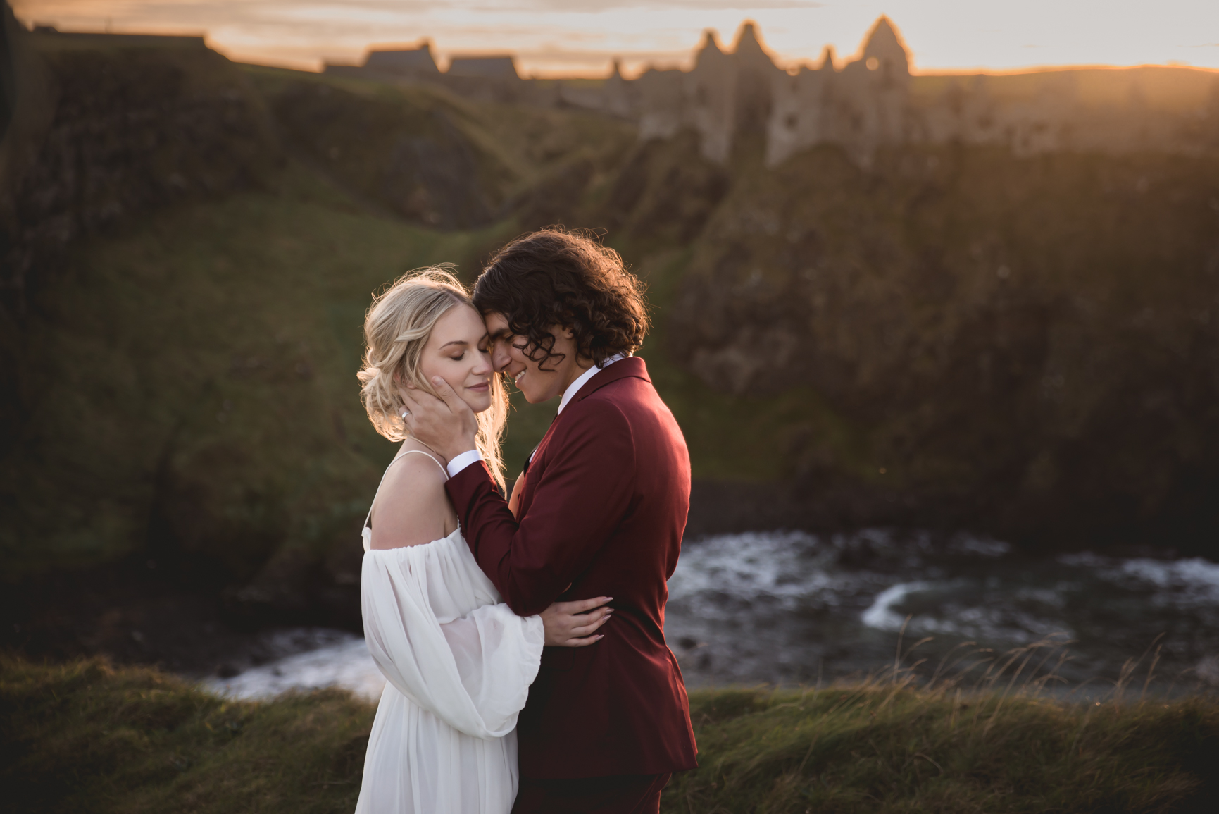 Bride and Groom sharing a kiss on clifftop sunset scene